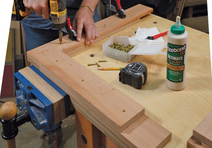 Asa drives screws into am L shaped assembly, which will make up one of the arms of the chair.