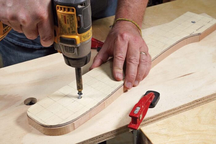 Asa drives a screw through a 1/4" piece of plywood. the holes are pre-drilled and countersunk. 