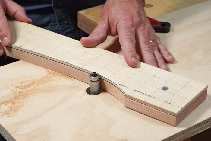Asa uses a flush trim bit to rout the cedar to match the templates. The bearing rides against the 1/4" plywood screwed to cedar. 