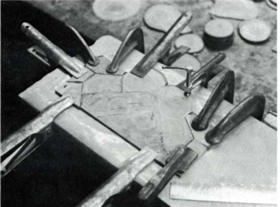 several clamps holding down end grain veneer segmments, which are edge glued together with epoxy.
